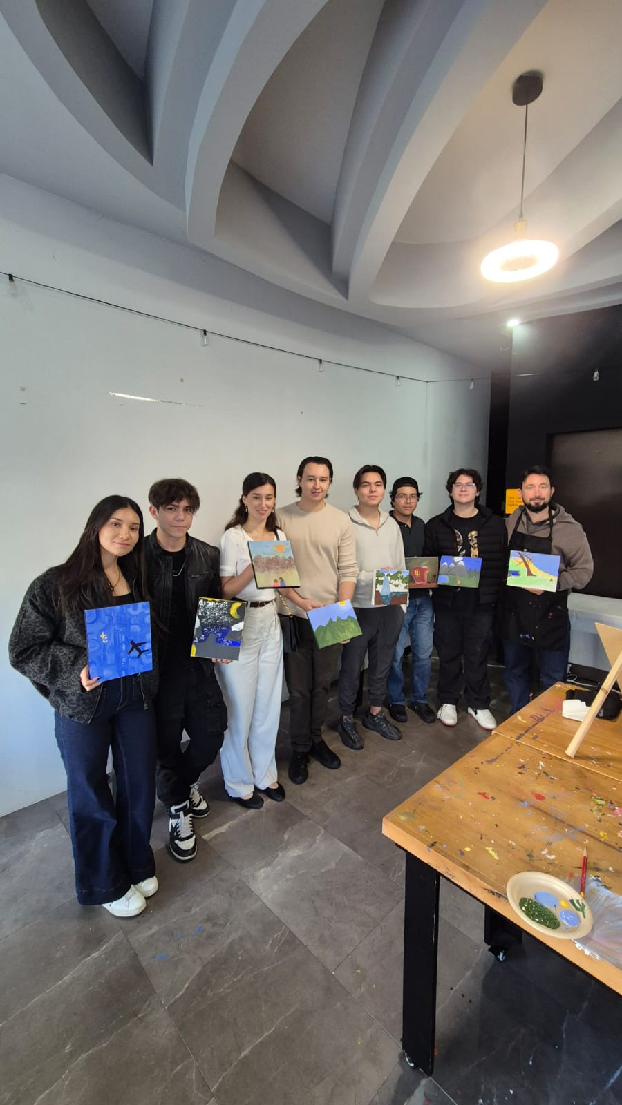 Miembros NextGen mostrando los cuadros que pintaron en un taller