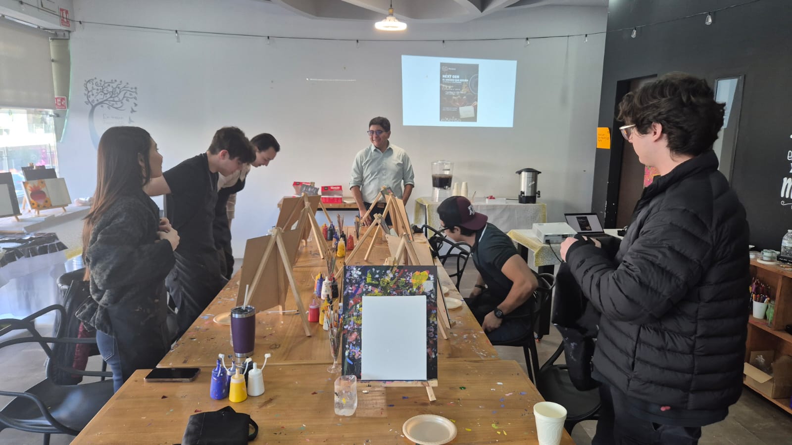 Jóvenes NextGen pintando alrededor de la mesa en un taller